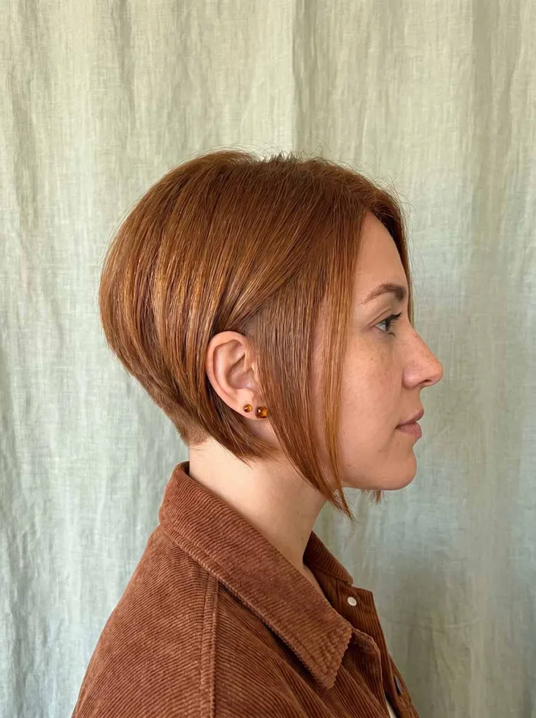 Woman with angled bixie haircut showing close-cropped back and longer angled front pieces toward the chin — angled bixie hairstyle