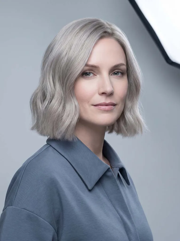 Woman with an ash blonde wavy bob, cool-toned platinum-beige waves at chin length