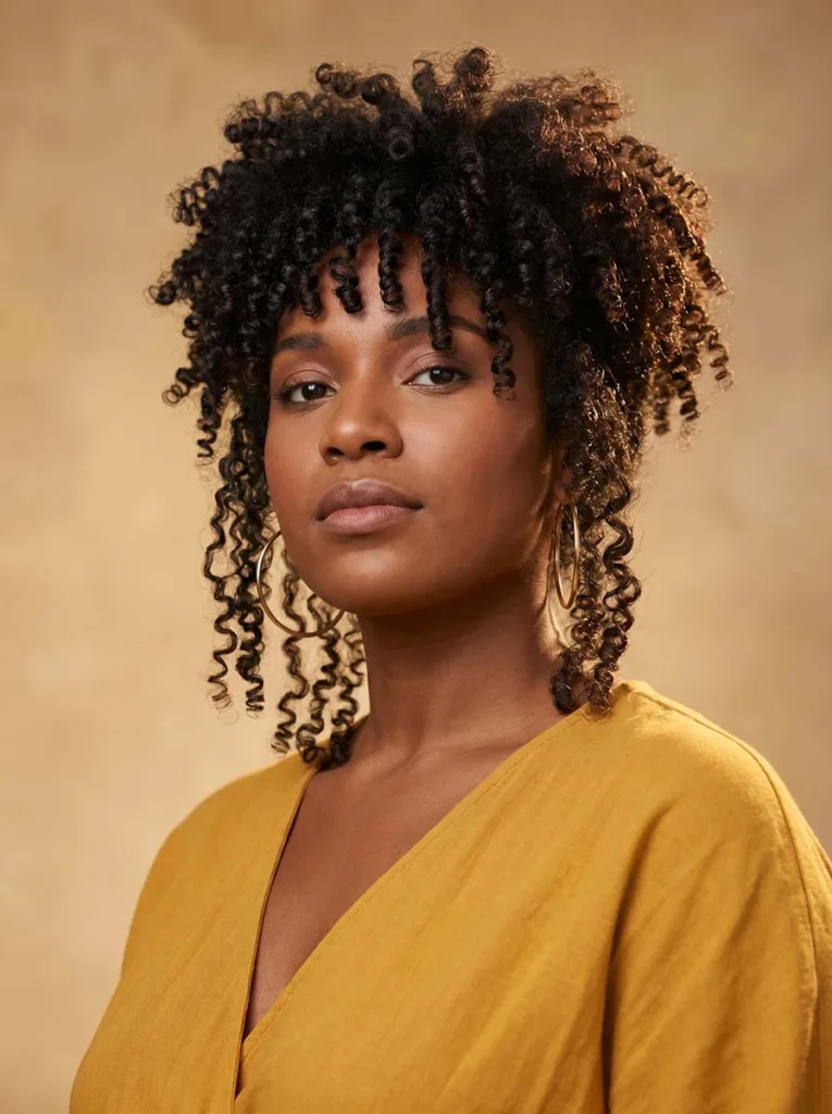 Woman with natural curly hair in a bixie haircut with defined curl texture — curly bixie haircut