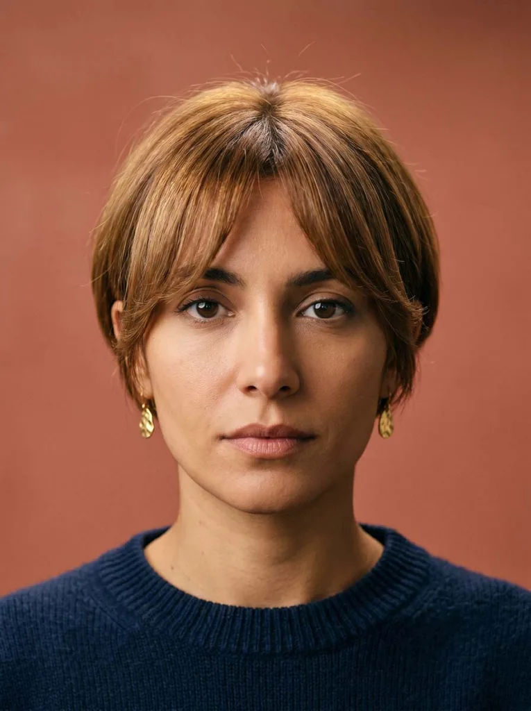 Woman with honey brown bixie cut and curtain bangs framing the face — bixie with curtain bangs