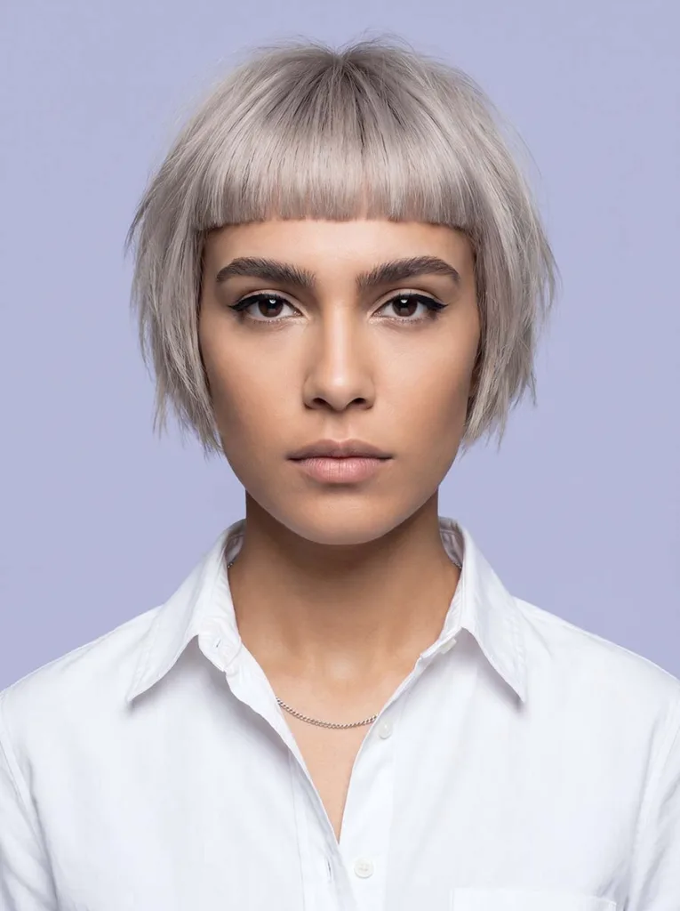 Woman with bixie haircut and short blunt micro-bangs above the brows — bixie with micro bangs