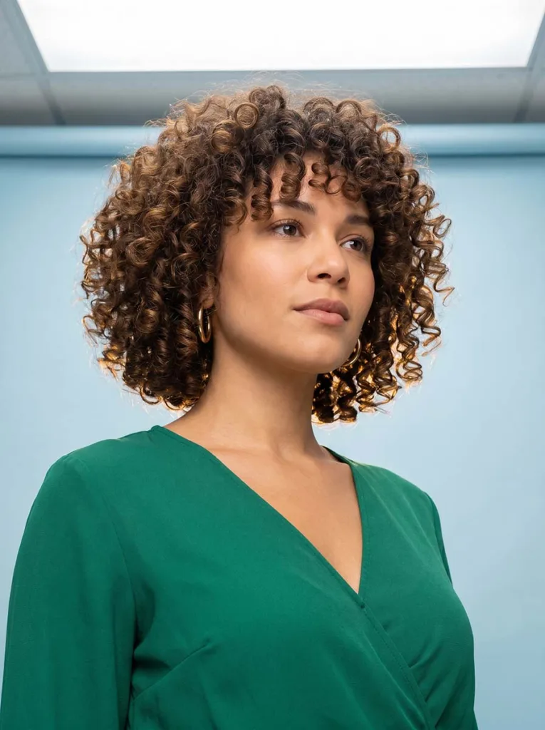 Woman with bouncy defined curls in a bixie haircut styled with diffuser — curly bixie haircut