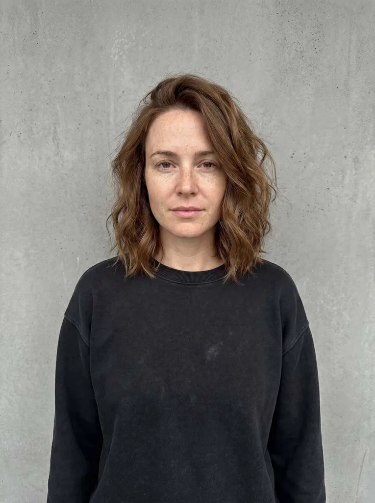 Woman with a tousled wavy lob, slightly messy waves falling at the collarbone
