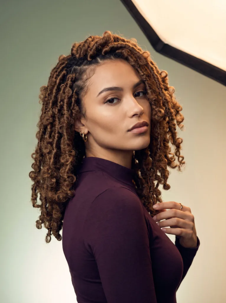 Young woman with fluffy textured butterfly locs in warm brown at shoulder length