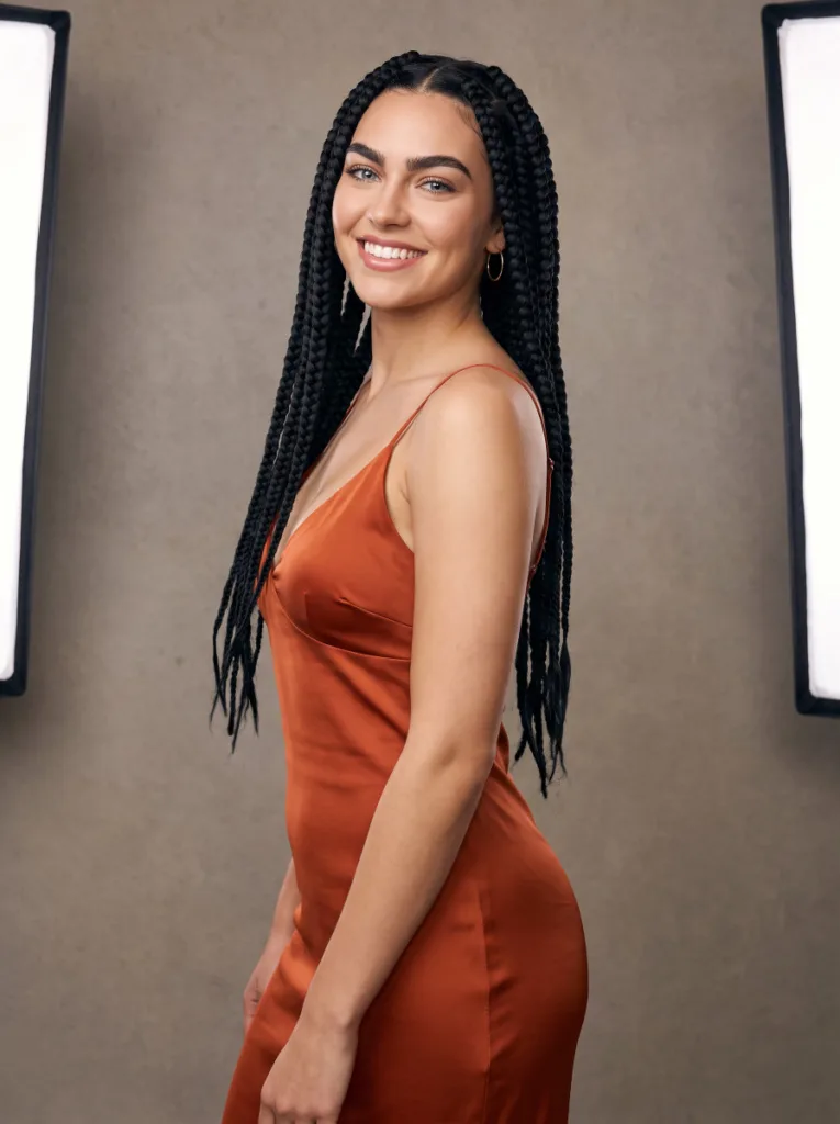 Confident young woman with thick jumbo knotless braids in jet black worn loose over both shoulders