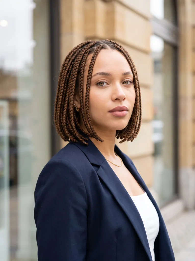 Stylish young woman with a jaw-length knotless braids bob in warm medium brown