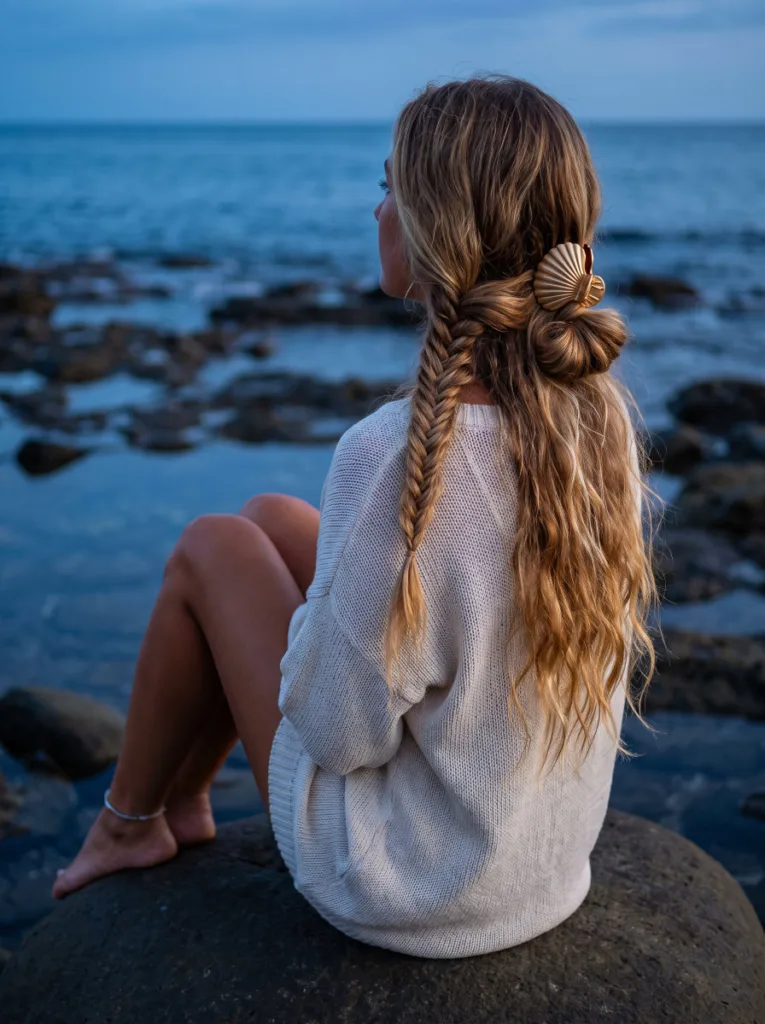 Boho fishtail shell clip bun on long hair with loose cascading ends at sunset beach