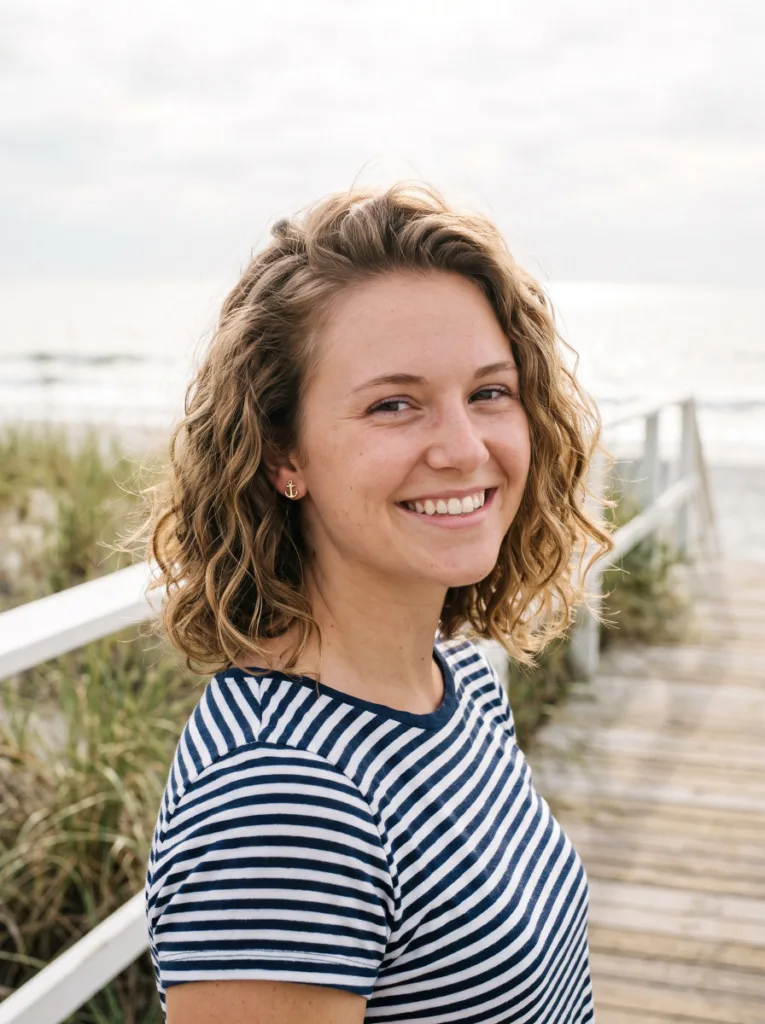 Woman with a textured lob coastal cowgirl wave hairstyle on a beach boardwalk
