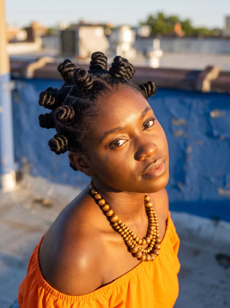 Young woman wearing a full head of Bantu knots on 4C natural hair