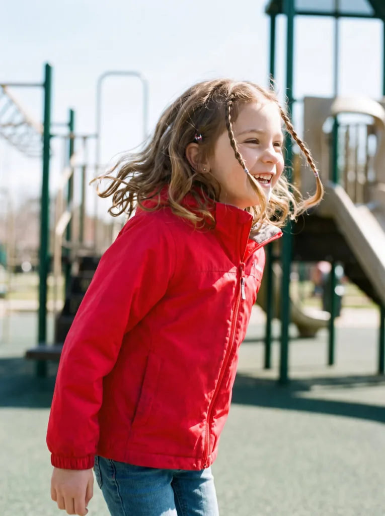Young girl with face-framing side twists hairstyle playing outdoors