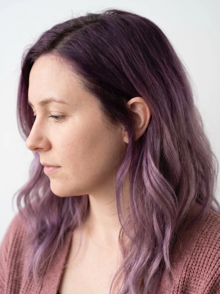 Woman with grape to amethyst tonal ombre hair color