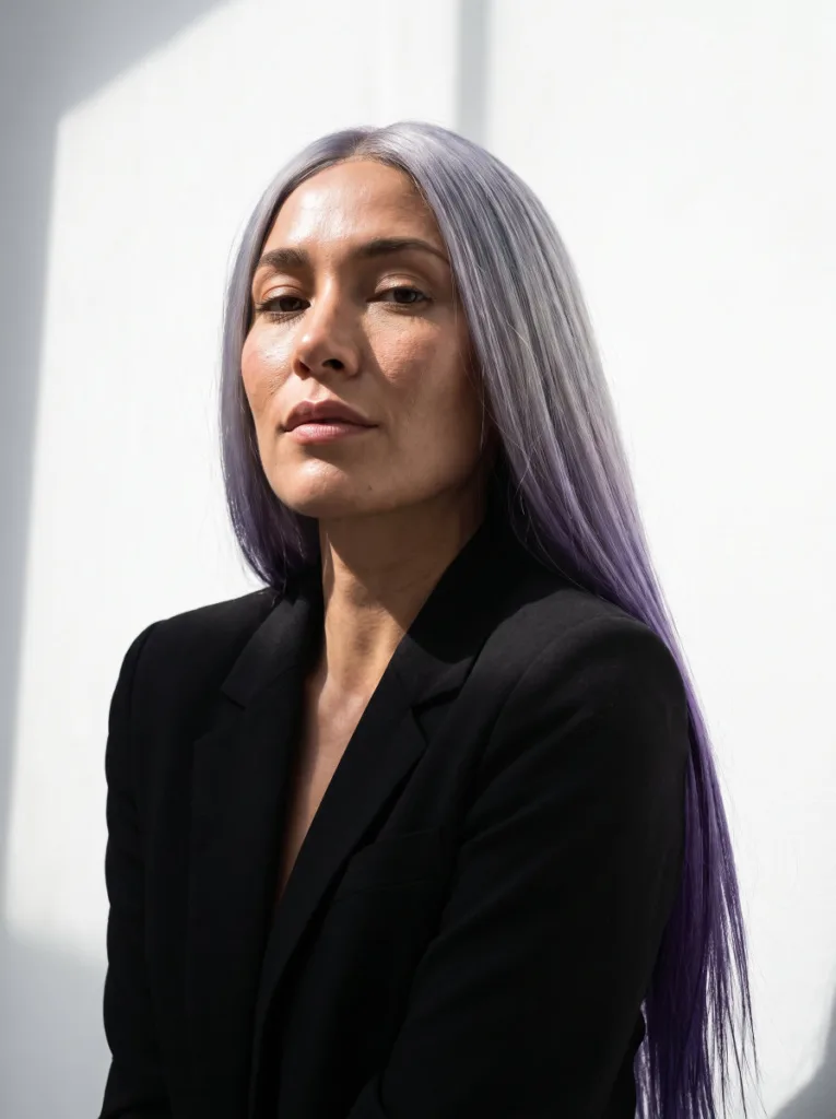 Woman with silver roots melting into violet hair color in a high-fashion portrait