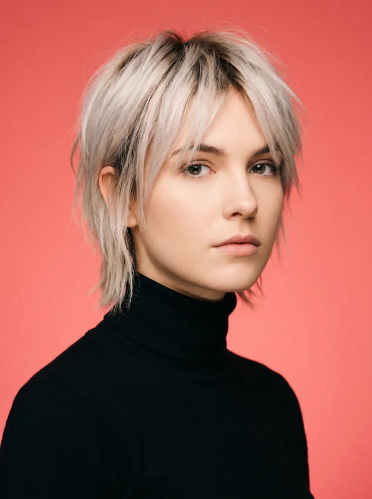 Woman with a short bixie haircut, a hybrid between a bob and a pixie cut, in a bold studio portrait