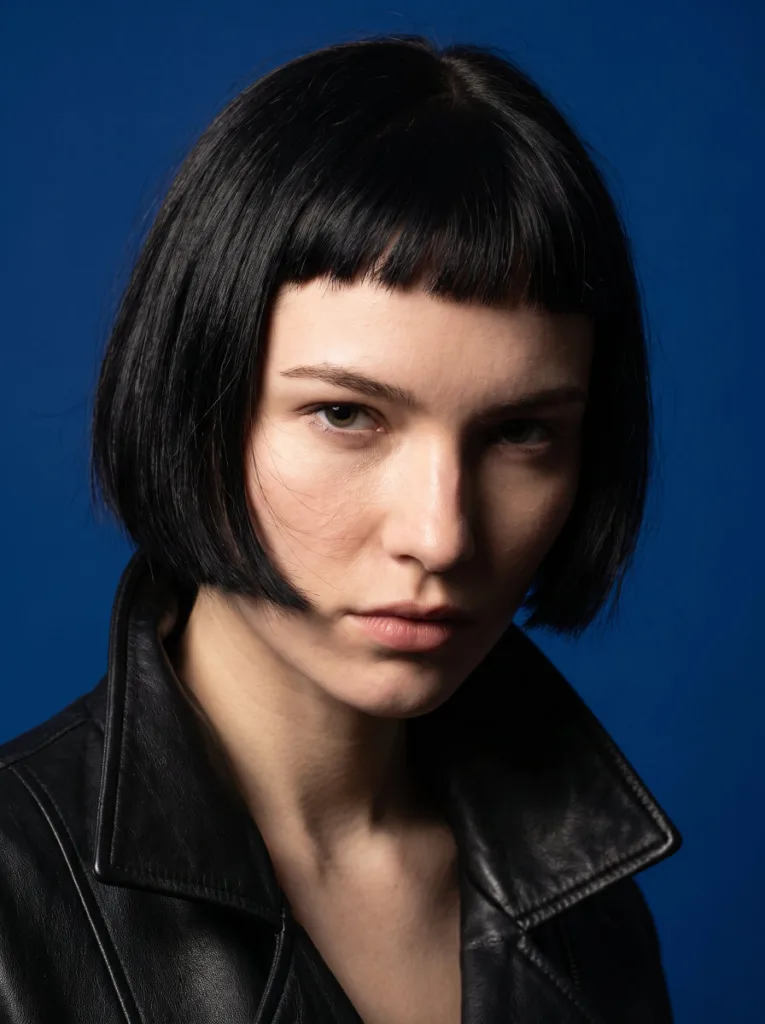 Woman with a blunt bob and bold baby bangs at chin length