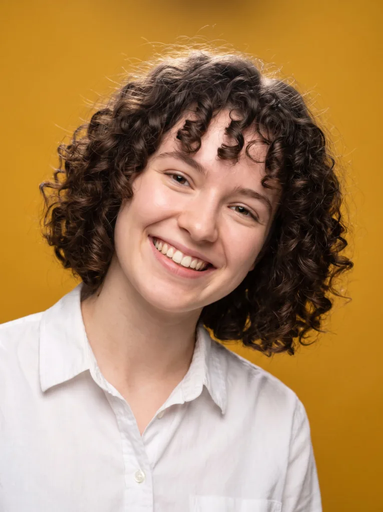 Woman with a curly chin length bob showing defined natural curls