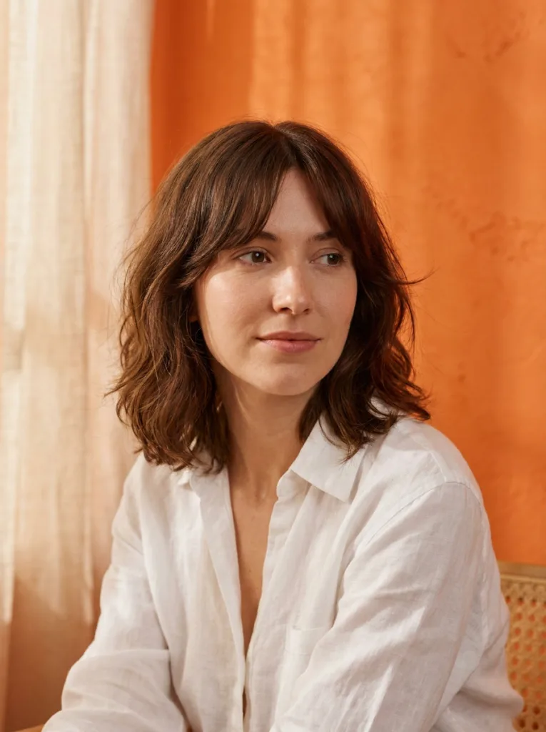 Cherub cut with a center-parted curtain fringe blending into soft wavy side layers