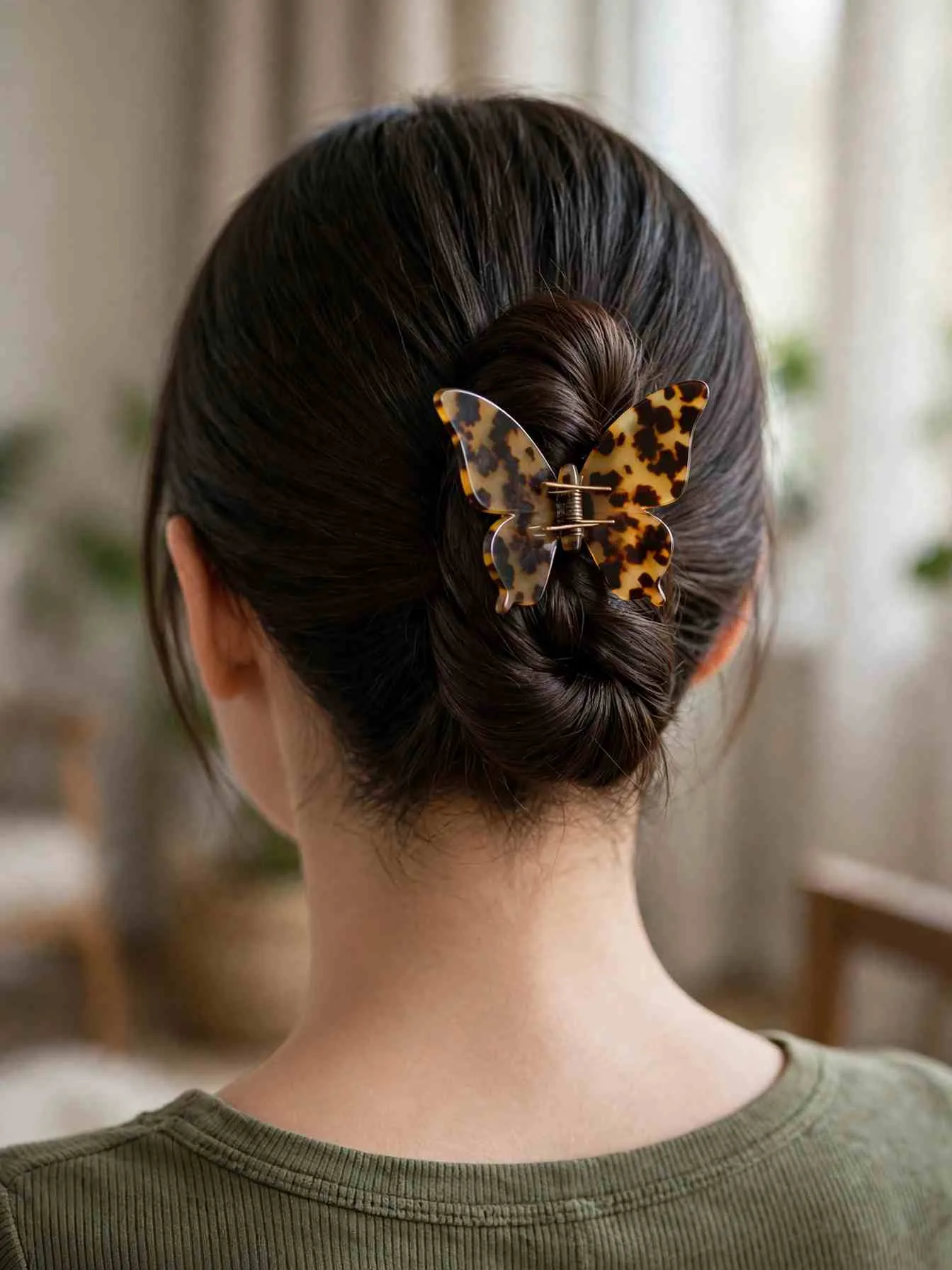 Low twisted bun secured with one medium butterfly clip at the nape