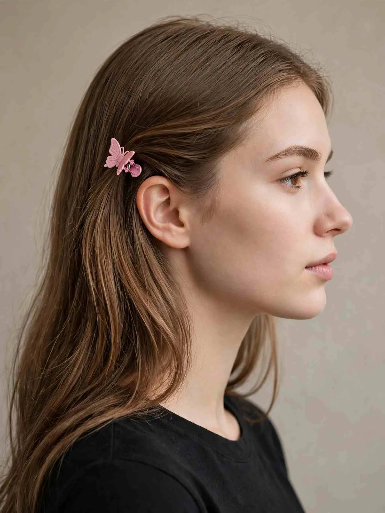 Side-swept hair pinned behind the ear with a mini butterfly clip