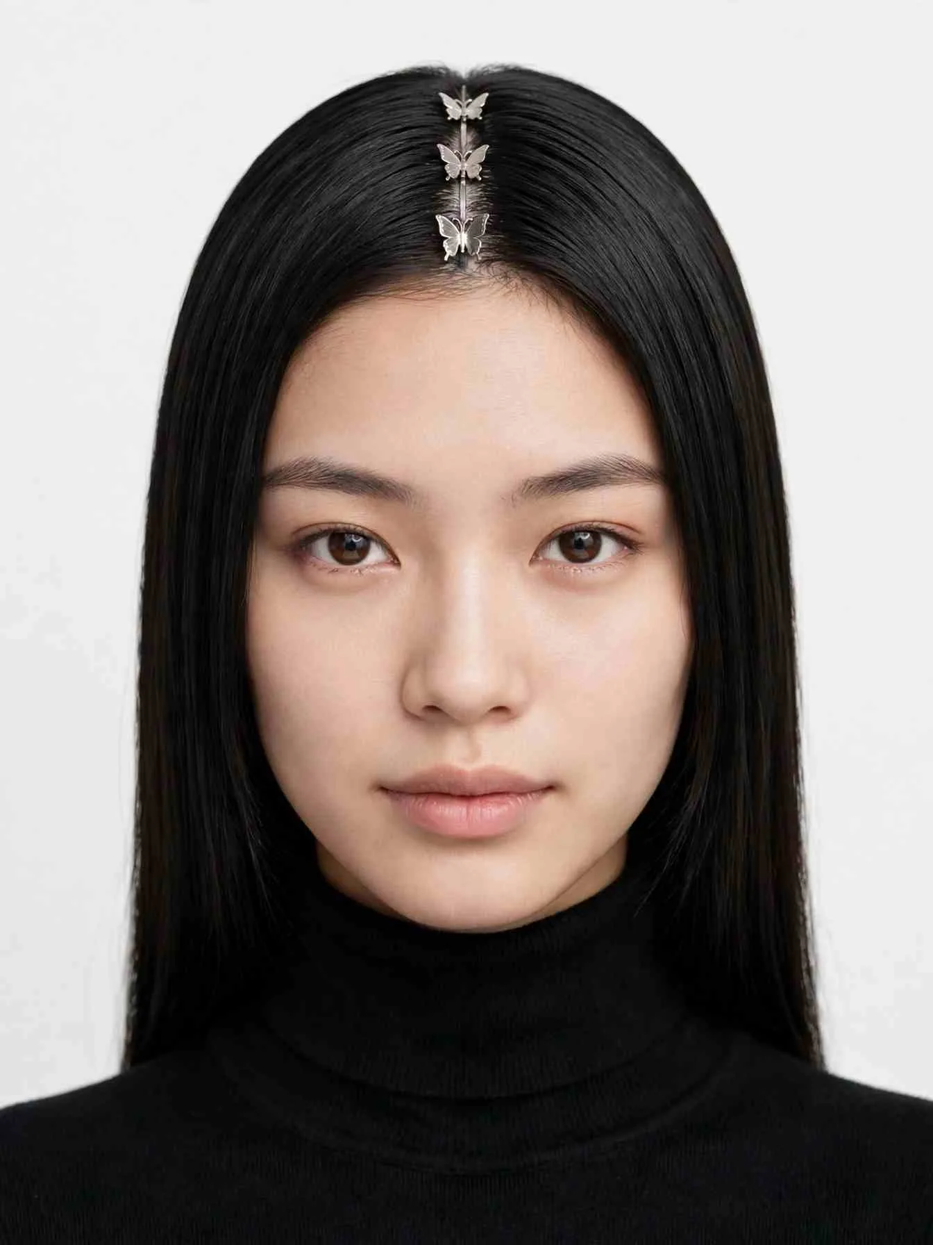 Sleek center part with three mini butterfly clips stacked down the middle