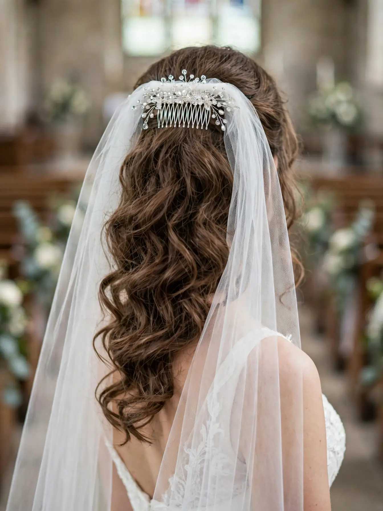 Romantic soft curls under a sheer bridal veil